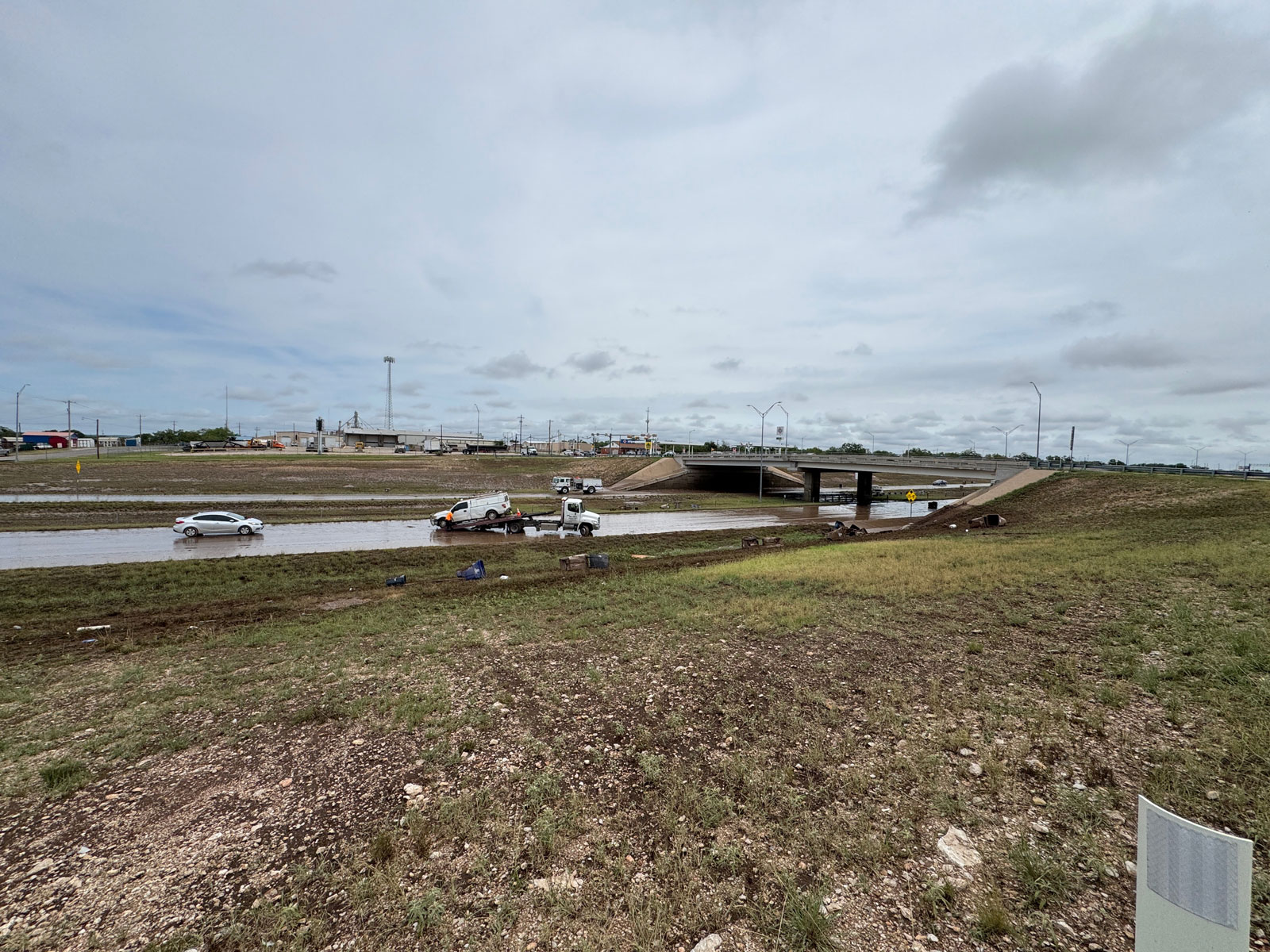 A wide view of Home Motors picking up the flooded out cars and trucks that dared to go through the high water underneath the Bell St. overpass on the Houston Harte Expy. on July 4, 2025. A wide view of Home Motors picking up the flooded out cars and trucks that dared to go through the high water underneath the Bell St. overpass on the Houston Harte Expy. on July 4, 2025.