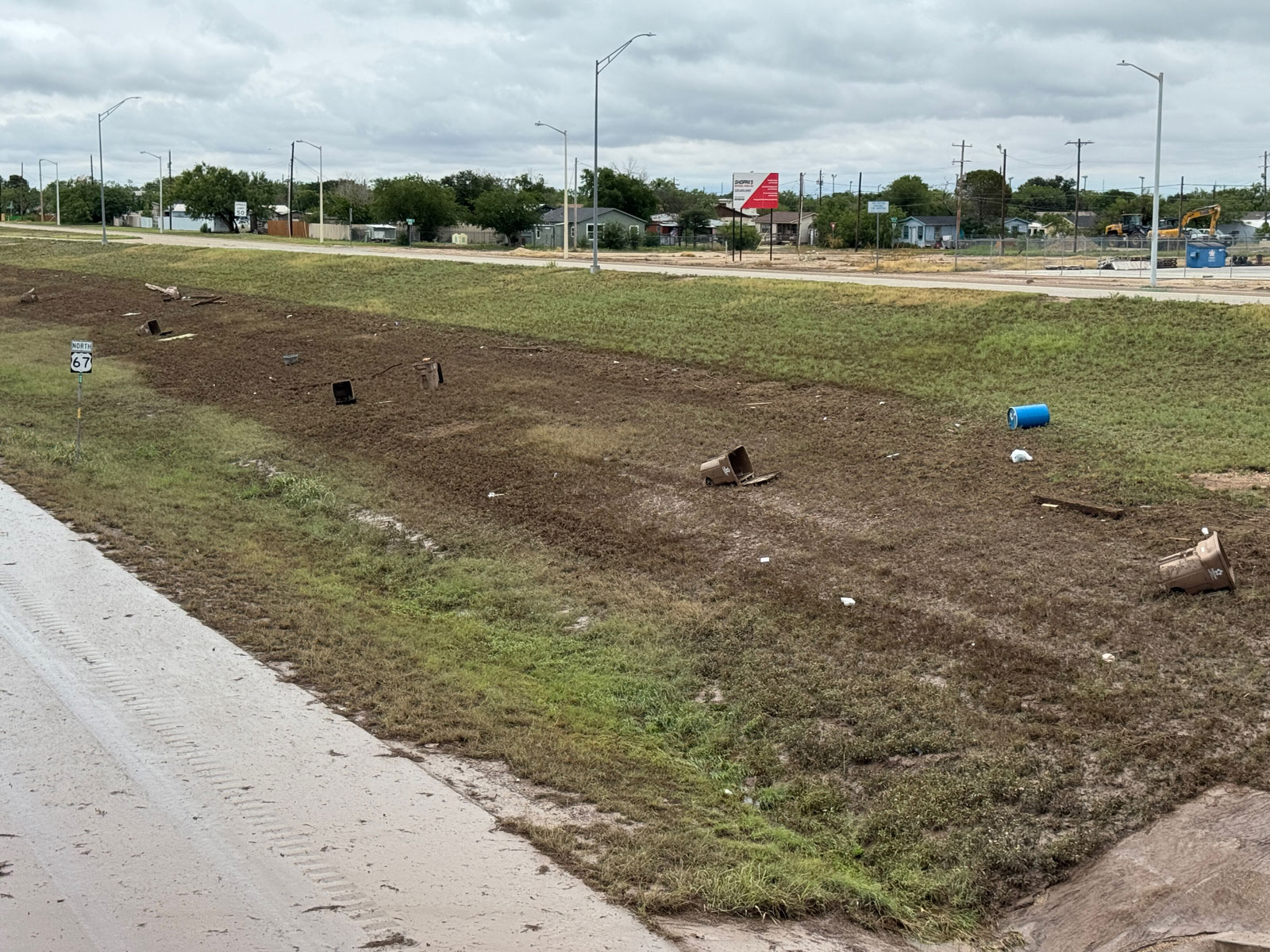 A view of the southeast embankment of the Houston Harte Expy. where residential trash carts line the water line, displaying how high the water rose on July 4, 2025. A view of the southeast embankment of the Houston Harte Expy. where residential trash carts line the water line, displaying how high the water rose on July 4, 2025.