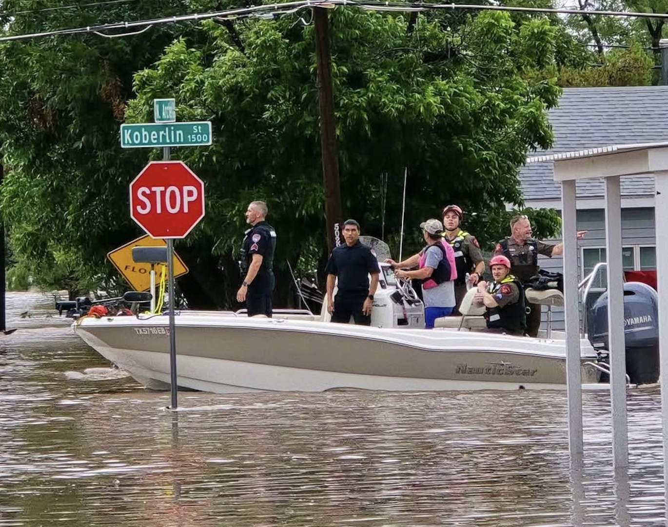 Police are seen in a rescue boat at the intersection of Koberlin and Archer streets after heavy flooding Friday, July 4, 2025. Police are seen in a rescue boat at the intersection of Koberlin and Archer streets after heavy flooding Friday, July 4, 2025.