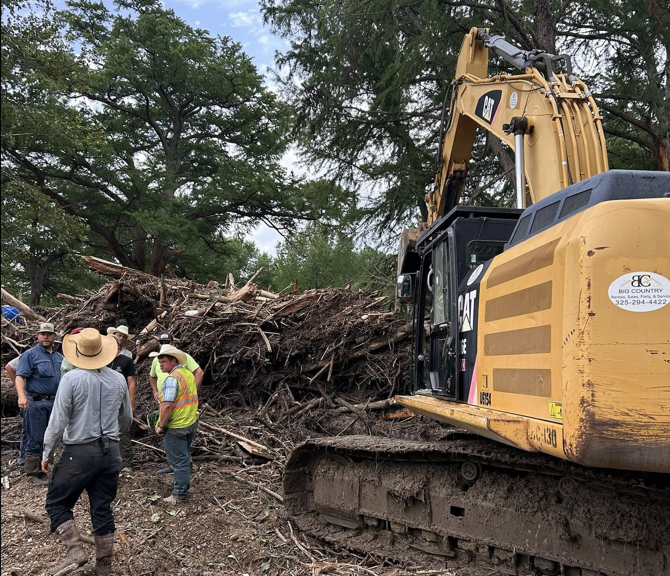 Workers sift through debris from the Guadalupe River flooding. Workers sift through debris from the Guadalupe River flooding.