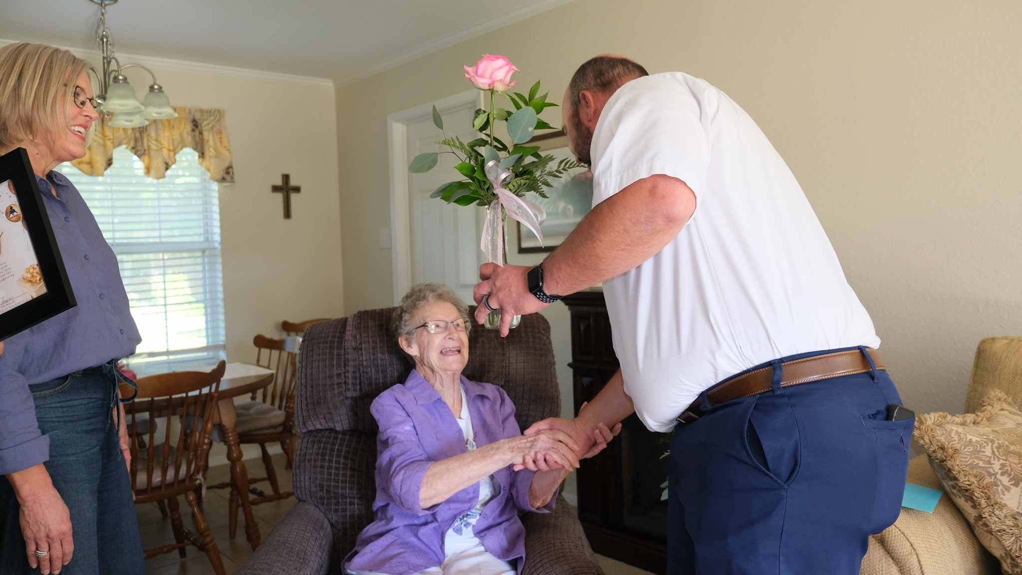 Lane Strickland, vice president of Meals for the Elderly, presents Ida Walter with a flower during her 101st birthday celebration on Friday in San Angelo.