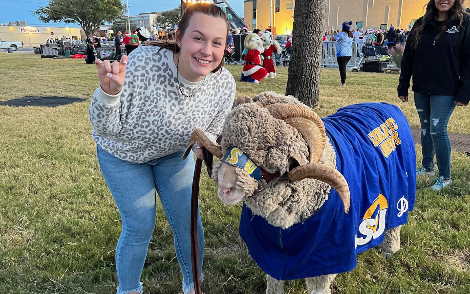 Angelo State University's official mascot, Dominic the ram, with his handler, Animal Science major Brenna Bell.