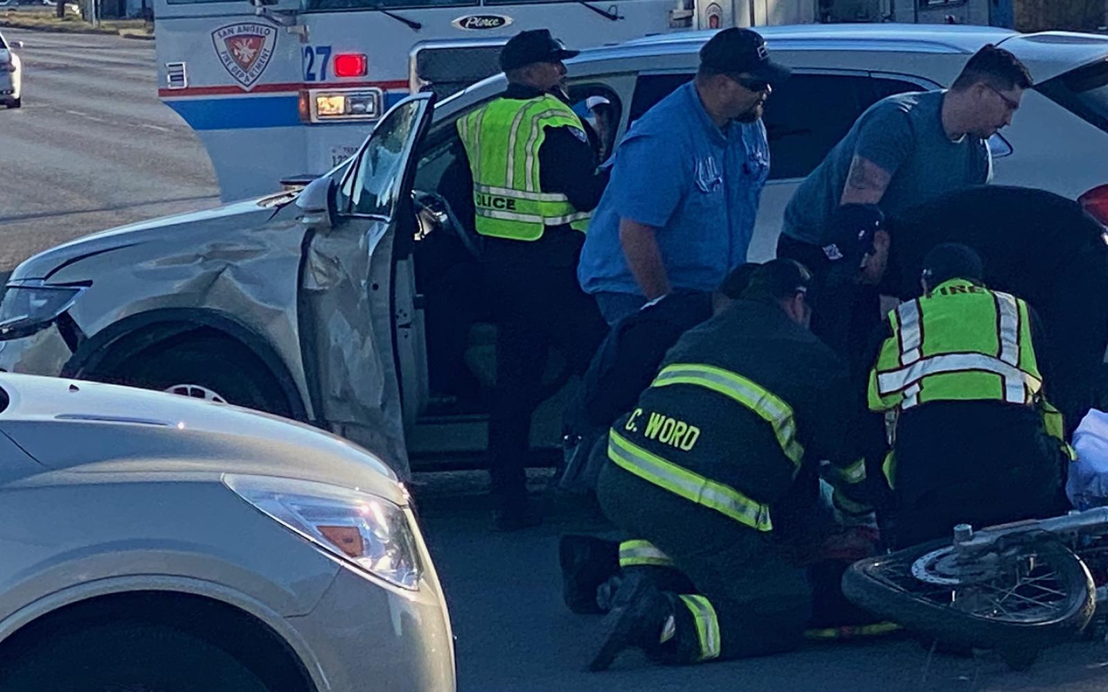 Medics stabilizing a crash victim who was on the motorcycle before rushing to hospital in ambulance.