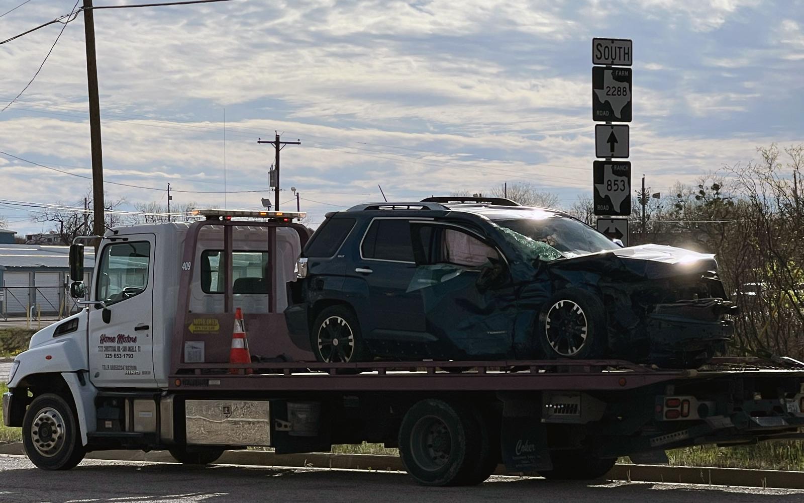 The blue GMC SUV is hauled away