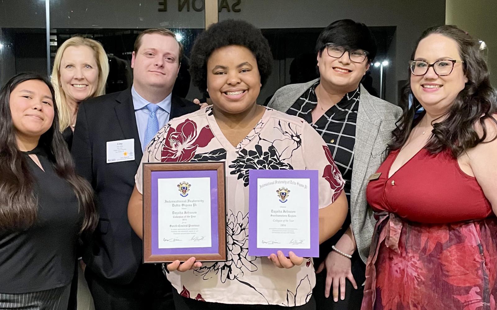 Daysha Johnson (center) with Delta Sigma Pi officials and her awards: