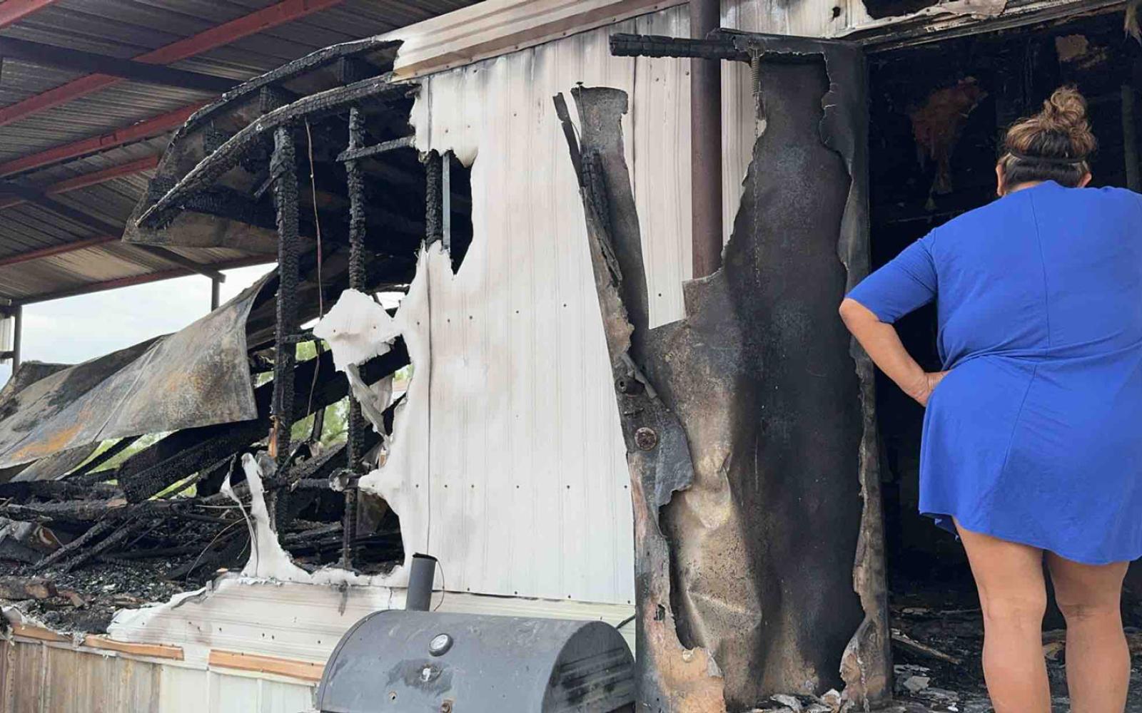 Rosa Coronado inspects the damage to her burned-out mobile home