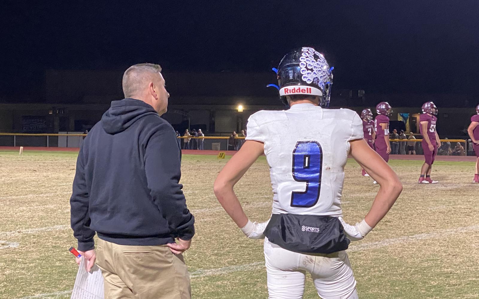 Richland Springs head coach Shawn Rogers talk to his son, quarterback Hutton Rogers, during the Coyotes' 64-6 second-round playoff win over Zephyr on Friday, Nov. 22, 2024.