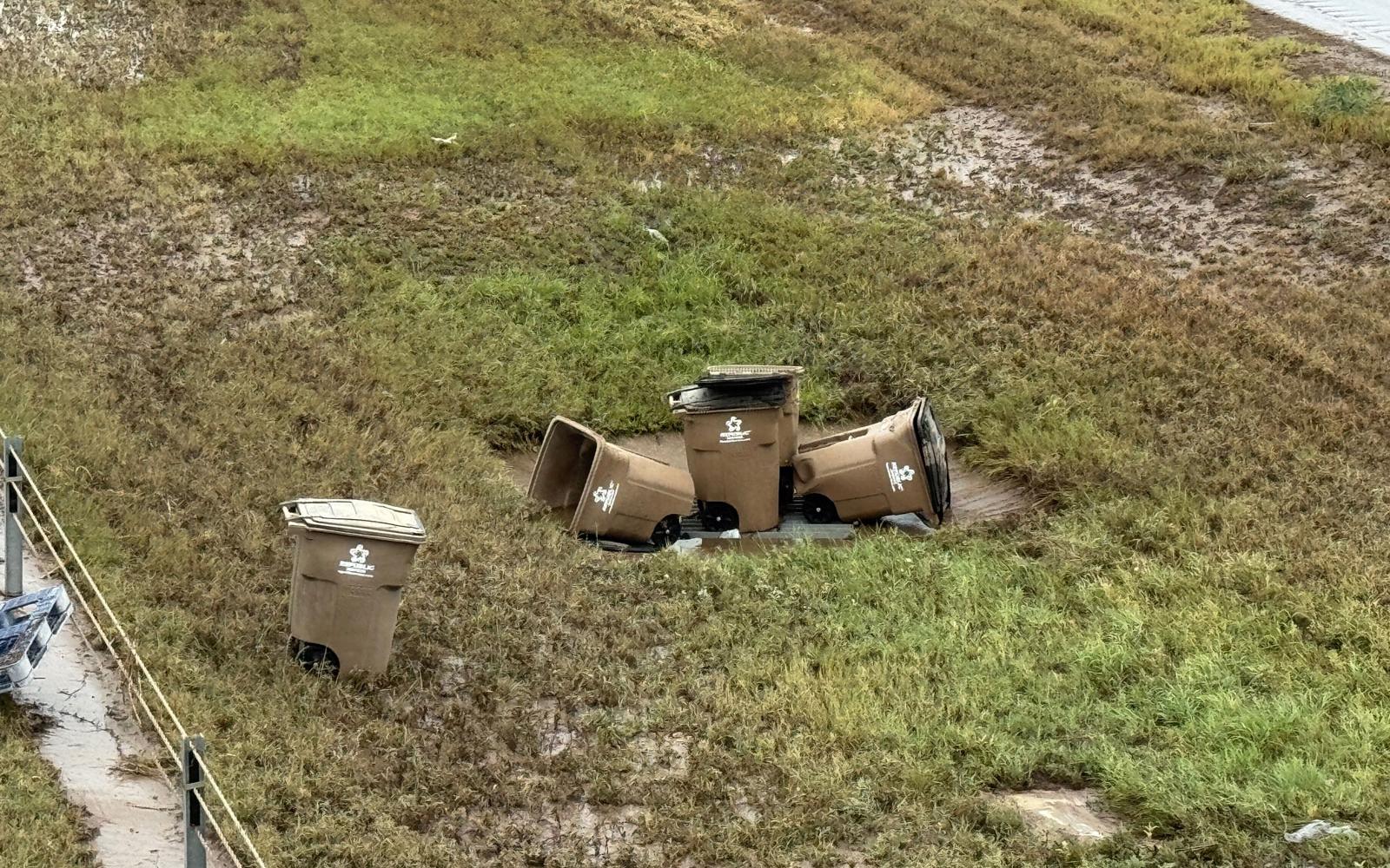 Many Toter trash containers washed into the Houston Harte Expy, likely from the East Ditch.