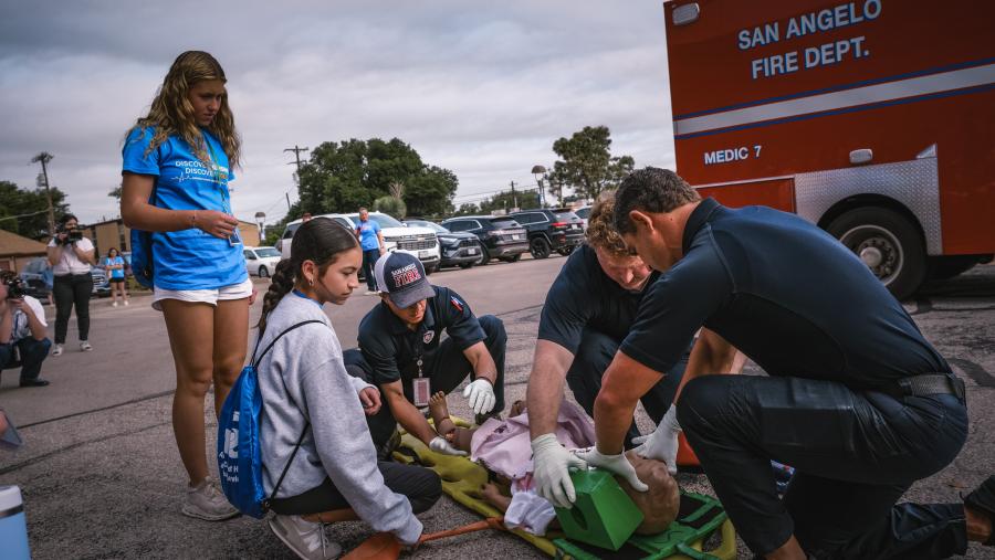 Campers observe as San Angelo Fire Department personnel demonstrate emergency care during a mock accident drill at ASU.