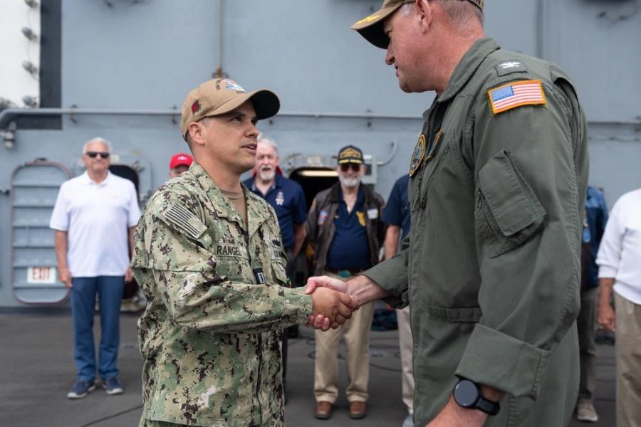 SAN DIEGO (June 9, 2025) U.S. Navy Lt. Michael Rangel, from San Angelo, Texas, left, shakes hands with Capt. Brian Schrum, commanding officer of the Nimitz-class aircraft carrier USS Theodore Roosevelt (CVN 71) after receiving the U.S. Naval Academy Class