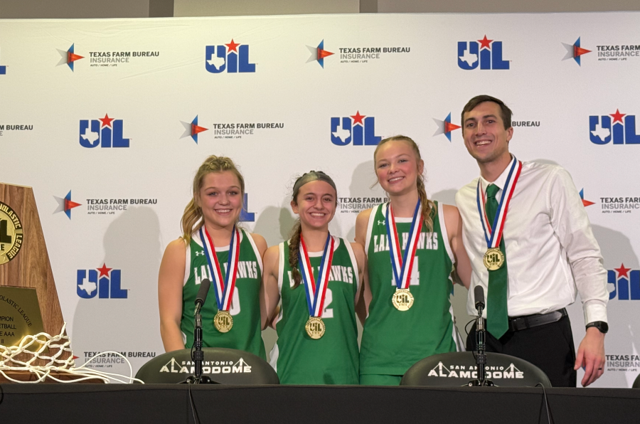 Wall basketball players (from left) Kennedi Graves, Kathrine Lewis and Emery Harper pose with head coach Silas Crisler after their state championship win Monday, March 6, 2026.