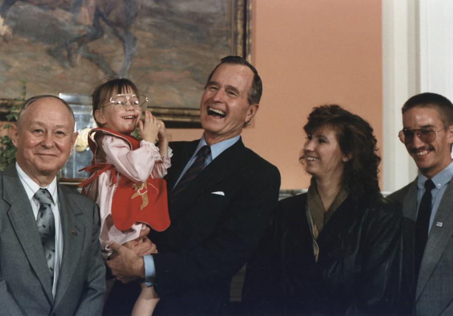 President George Bush holds "Baby Jessica" after her rescue from a well in 1987.