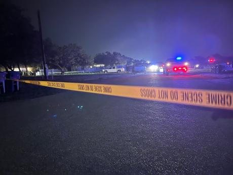 Crime tape blocking off a large area around the house where two law enforcement officers were gunned down the night of May 10, 2021 in Eden, Texas.