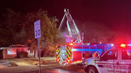 A red car was damaged by flames. San Angelo firefighters battled a fully-engulfed house fire on the evening of Sunday, Nov. 28, 2021