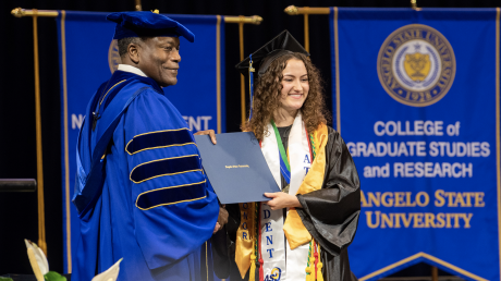 Morgan Preston receiving her diploma from ASU President Ronnie Hawkins Jr. in May 2022