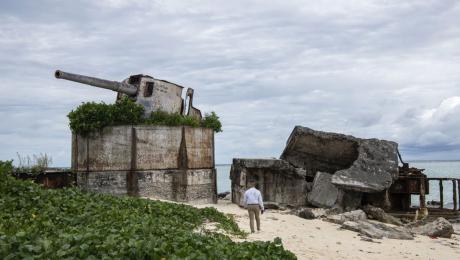A U.S. Marine walks towards a weapon used during the Battle of Tarawa during World War II at Tarawa, Kiribati on July 17, 2019. Along with participating in the Repatriation Ceremony for the possible remains of U.S service members that were brought back to the United States, Marines were also given a tour of the Island and taught of the history of the Battle of Tarawa. (U.S. Marine Corps photo by Cpl. Taryn Escott)