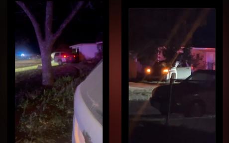 Emergency vehicles illuminate the scene at 201 Oakwood St. after a vehicle reportedly crashed into a home. Witnesses say the driver fled on foot, and police were seen detaining an individual as the investigation unfolded.