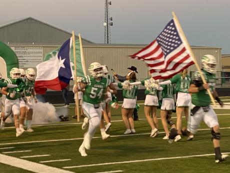 The Wall Hawks football team charges onto the field before its first-round playoff game with Anthony on Friday, Nov. 15, 2024.