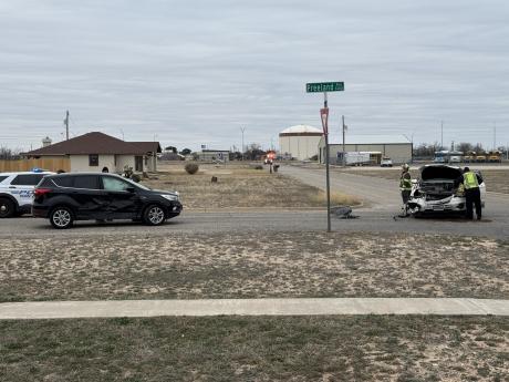 San Angelo Fire Department personnel work near a white Chevy Traverse, which sustained significant front-end damage in the crash at Freeland Avenue and Alexander Drive.