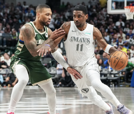Kyrie Irving of the Dallas Mavericks drives past Damian Lillard of the Milwaukee Bucks
