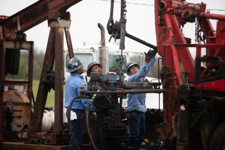 Oil workers pull tubing from an orphan well in a field in Luling on March 27, 2025