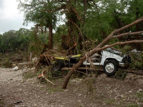 A destroyed vehicle caught in between trees in Hunt, a small town where the the north and south forks of the Guadalupe River meet, about 13 miles west of Kerrville.