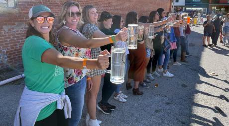 Female contestants see how long each can hold a beer stein at the 2023 Plateauberfest at Plateau Brewery Co.