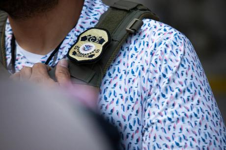 A U.S. Immigration and Customs Enforcement agent’s badge in front of the J.J. Pickle Federal Building in Austin on April 1, 2025. 