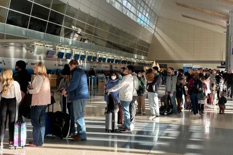 American Airlines passengers wait in a TSA security line at Dallas Fort Worth International Airport, Dec. 18, 2022. 