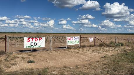 Protest signs near the proposed Beacon Data Centers project site in southwest Tom Green County