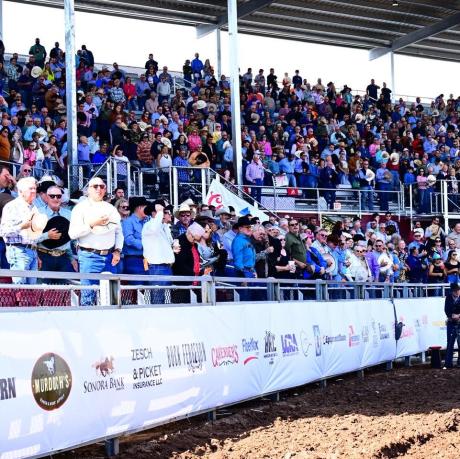 The crowd stands for the national anthem during the Cinch Roping Fiesta.