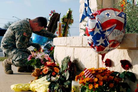 U.S. Army Specialist Robert Orcutt prays near a makeshift memorial for victims of the shootings at Fort Hood Army post in Fort Hood on Nov. 9, 2009.
