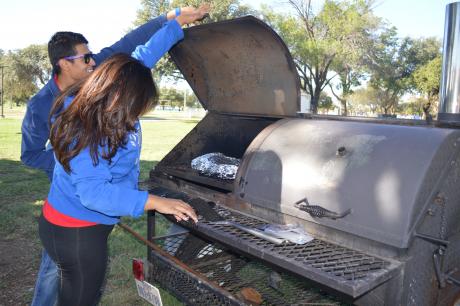 Emily Banda and Henry Luna check on their brisket. (LIVE! Photo by Lauren Lopez)