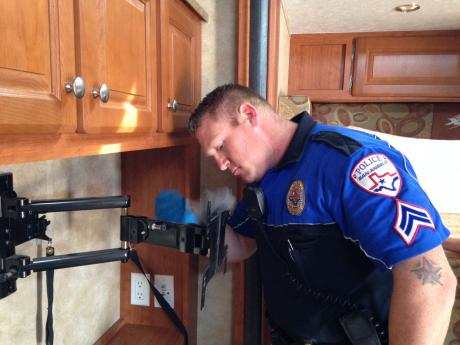 Lake Division Officer James Beddo fingerprints a TV mount after a burglary. (LIVE! Photo by Chelsea Schmid)