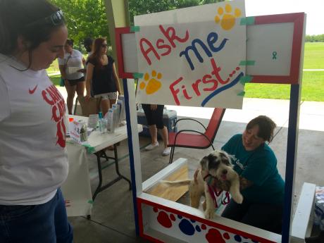 Volunteers accept donations at puppy kissing booth. (LIVE! Photo/Jessica Wilder)