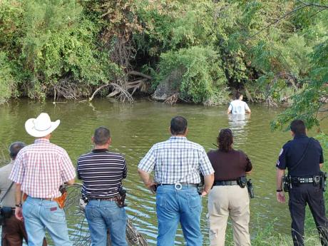 Game Warden, Tom Green County Sheriff's Deputies, and San Angelo police fish suspect out of the Concho River behind Central High School. (LIVE! Photo/Joe Hyde)