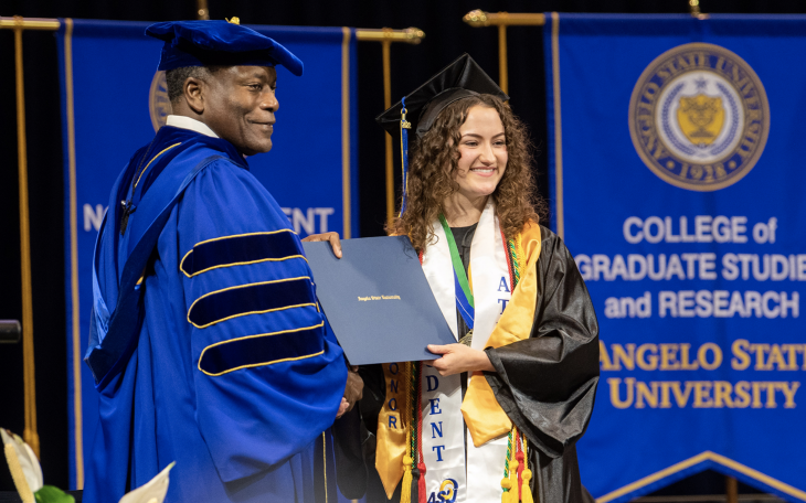 Morgan Preston receiving her diploma from ASU President Ronnie Hawkins Jr. in May 2022