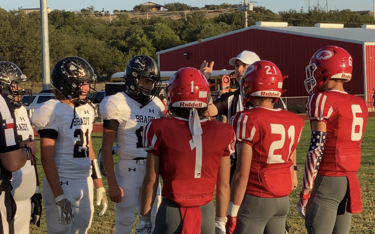 Captains for the Brady Bulldogs and Christoval Cougars meet at midfield for the coin toss.