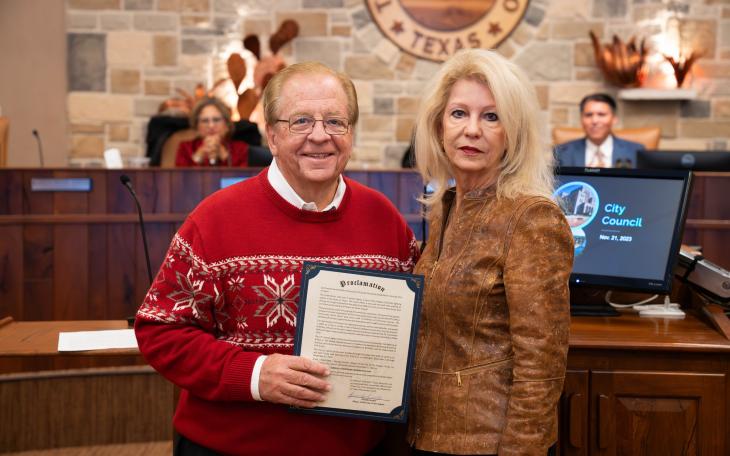Lee Pfluger (L) and Mayor Brenda Gunter, the Titans of Downtown San Angelo, come together to announce the Proclamation of December 2, 2023 as Concho Christmas Celebration Day.
