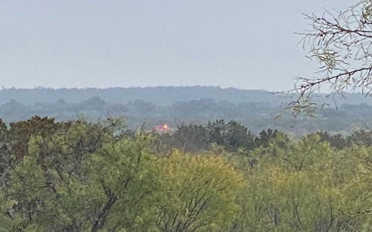 A San Angelo Fire &amp; Rescue EMS ambulance at the crash scene far off in the distance.