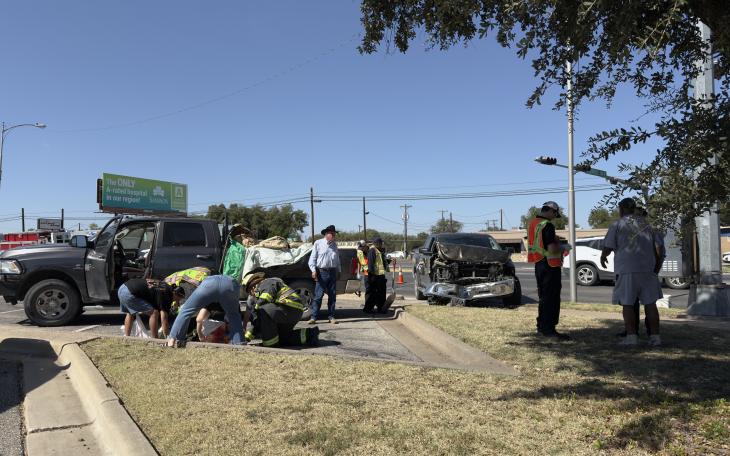 First responders assess the scene after two Dodge Ram pickups collided near the intersection of North Taylor Street and Sherwood Way. One of the trucks sustained heavy front-end damage, while no serious injuries were reported.