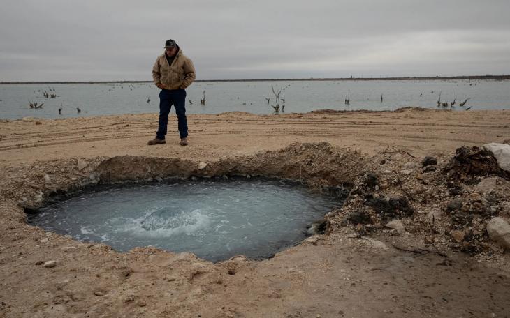 Hawk Dunlap stands at the site of Lake Boehmer, a brine lake that has leaked out of an old well in Pecos County. The Texas Commission on Environmental Quality received $10 million from lawmakers in 2023 to plug such wells but has yet to spend any of the money as it completes the rule making process.