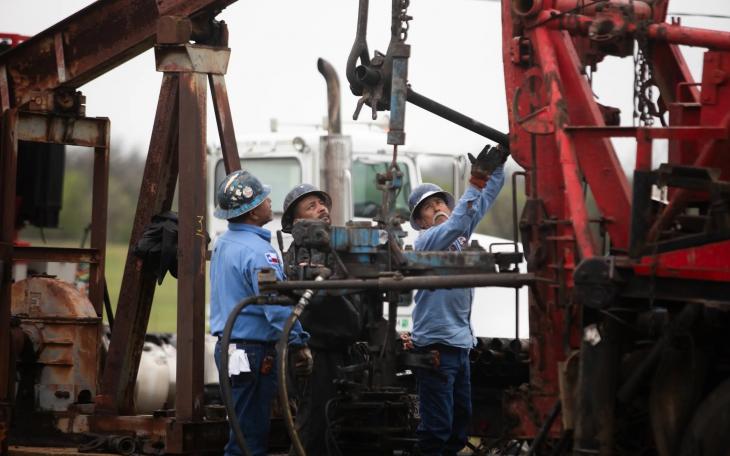 Oil workers pull tubing from an orphan well in a field in Luling on March 27, 2025