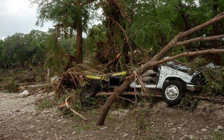 A destroyed vehicle caught in between trees in Hunt, a small town where the the north and south forks of the Guadalupe River meet, about 13 miles west of Kerrville.