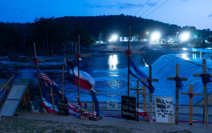 Crosses honoring the victims of the Hill Country floods, seen on July 11, 2025, were erected by artist Roberto Marquez next to the Guadalupe River in Guadalupe Park. Search efforts were suspended Sunday amid new warnings of potential flash flooding in the region. Storms on Sunday brought more floods across Central and North Texas, leading to rescues and evacuations in several counties. Credit: