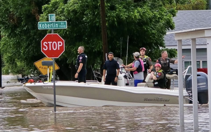 Police are seen in a rescue boat at the intersection of Koberlin and Archer streets after heavy flooding Friday, July 4, 2025.