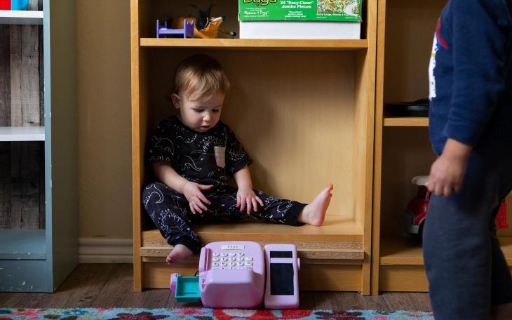 A child sits in a bookshelf at Kid's Castle Family Daycare and Preschool in Pflugerville in 2022.
