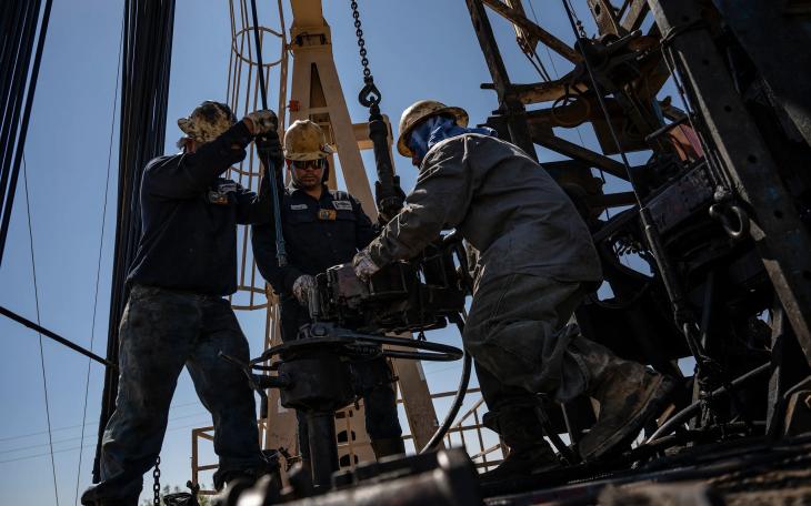 A service rig crew pulls sucker rods from an oil and gas well as they work to bring a downhole pumping unit to the surface on Aug. 14, 2024, in West Odessa.