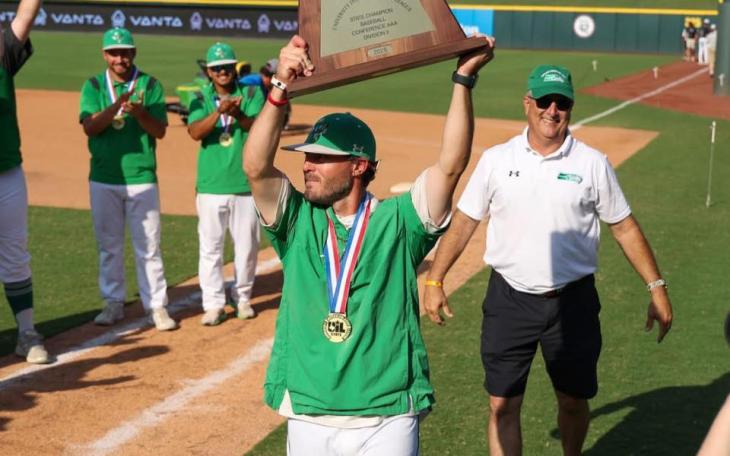 Wall baseball coach Jeremy Gordon hoists the trophy after the Hawks' state-title win over Thrall in 2025.