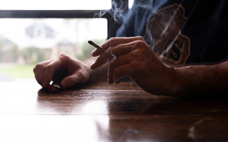 A man smokes a joint rolled from legal hemp flower in Onalaska on June 15, 2025.